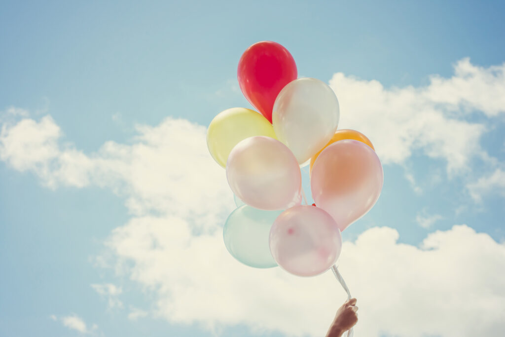 hand-holding-balloons-of-different-colors